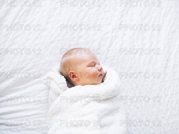 Baby boy (2-5 months) sleeping in white blanket