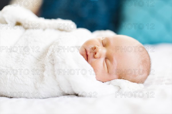 Baby boy (2-5 months) sleeping in white blanket