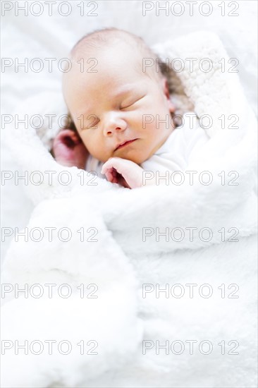 Baby boy (2-5 months) sleeping in white blanket