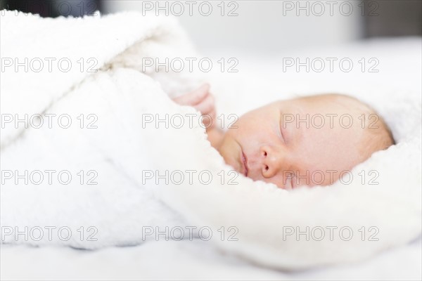 Baby boy (2-5 months) sleeping in white blanket