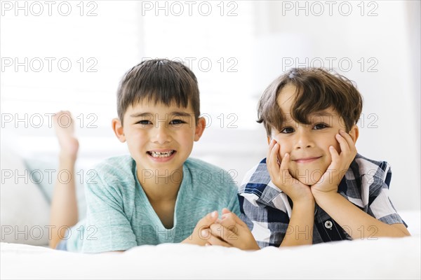 Siblings (6-7, 8-9) lying in bed side by side