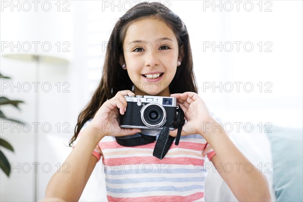 Smiling girl  (10-11) with camera
