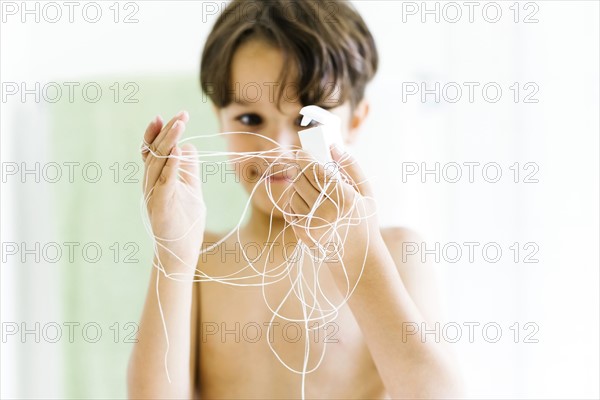 Boy (6-7) watching dental floss