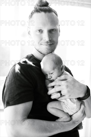 Portrait of man holding his on day son (0-1 months)