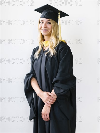 Portrait of young blond woman wearing graduation gown