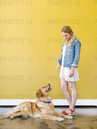 Young woman playing with golden retriever