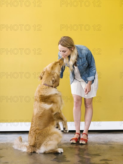 Young woman playing with golden retriever