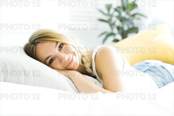 Portrait of young woman lying on bed