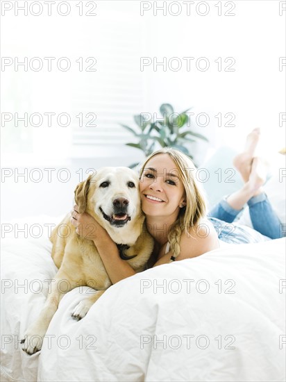 Young woman playing with golden retriever