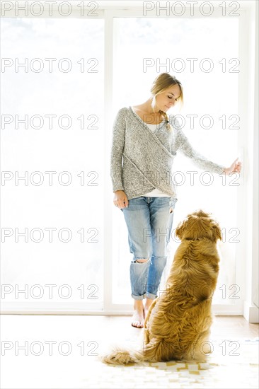 Young woman playing with golden retriever