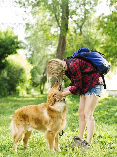 Young woman playing with golden retriever