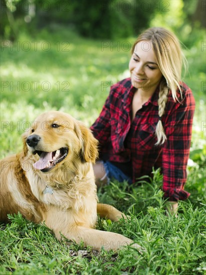 Young woman playing with golden retriever