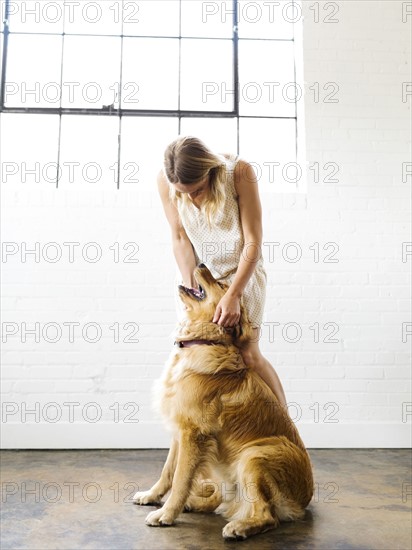 Young woman playing with golden retriever