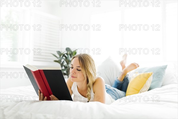 Woman reading book in bedroom