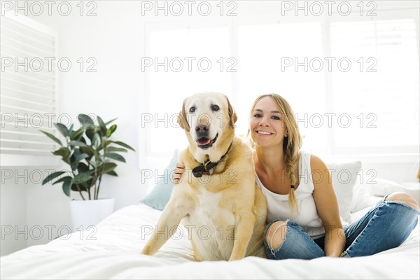 Portrait of blond woman with golden retriever