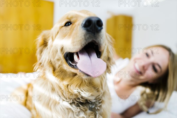 Portrait of blond woman with golden retriever