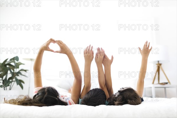 Brothers ( 6-7, 8-9 ) and sister ( 10-11 ) lying on bed and gesturing