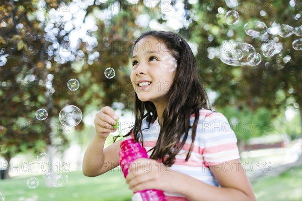 Portrait of girl ( 10-11 )  blowing soap bubbles