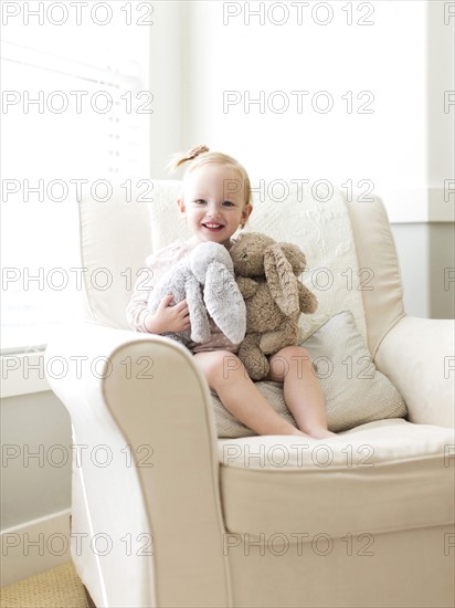 Portrait of girl ( 12-17 months ) holding stuffed toys