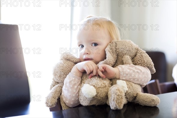 Portrait of girl ( 12-17 months ) holding stuffed toys