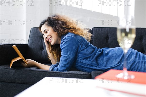 Woman watching tablet on sofa