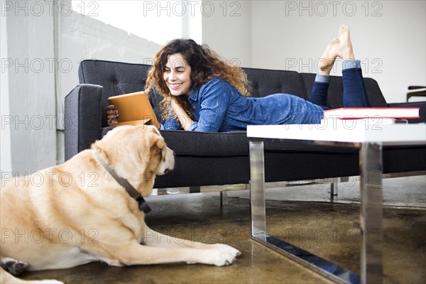 Woman watching tablet on sofa