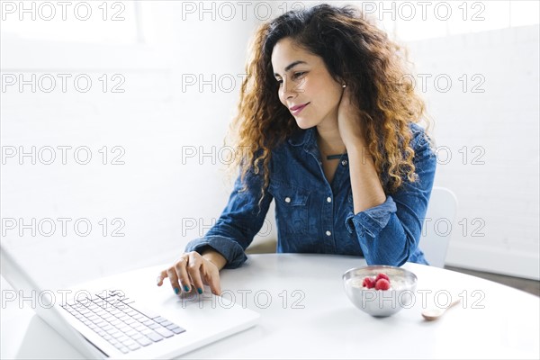 Woman using laptop at table