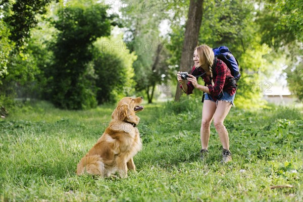 Woman photographing dog on hiking trip