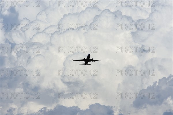 Airplane in sky with clouds in background