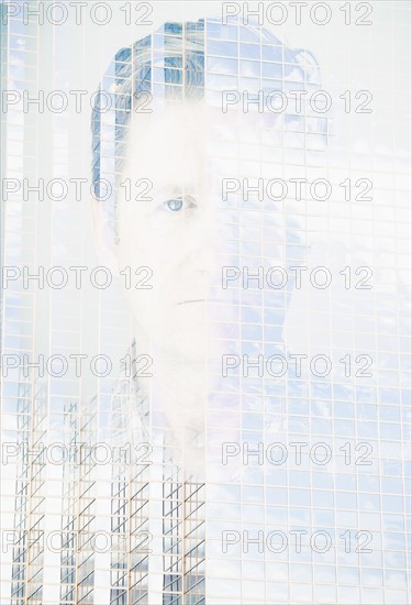 Double exposure portrait of mature man on office building facade