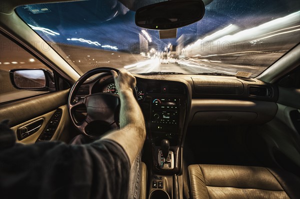 Interior of car driving through city streets at dusk