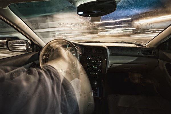 Interior of car driving through city streets at dusk