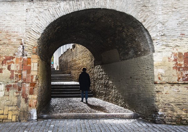 Spain, Seville, Triana, Woman walking through Cajellon De La Inquisicion