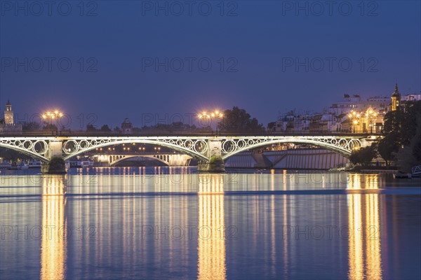 Spain, Seville, Triana, Guadalquivir River and Puente de Isabel II at dusk