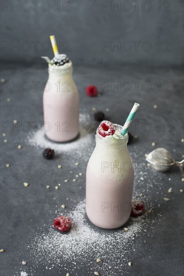 Studio shot of raspberry milkshake in bottles