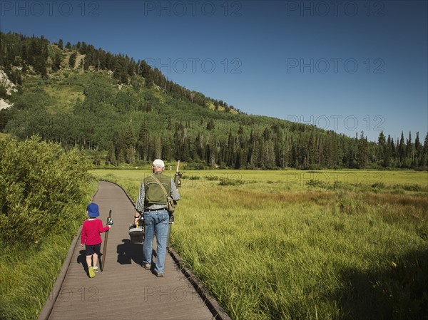 USA, Utah, Lake City, Boy (4-5) with grandfather walking on boardwalk through wetland