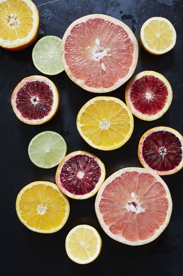 Halved fruits on black background