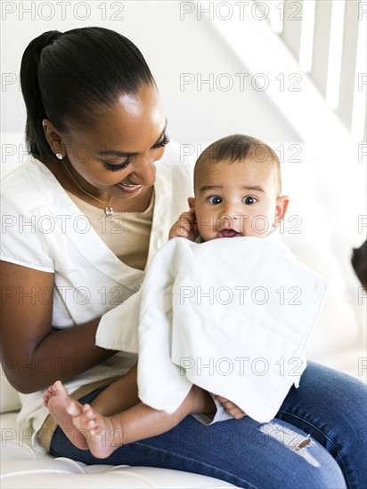 Mother and baby boy (2-5 months) sitting on sofa