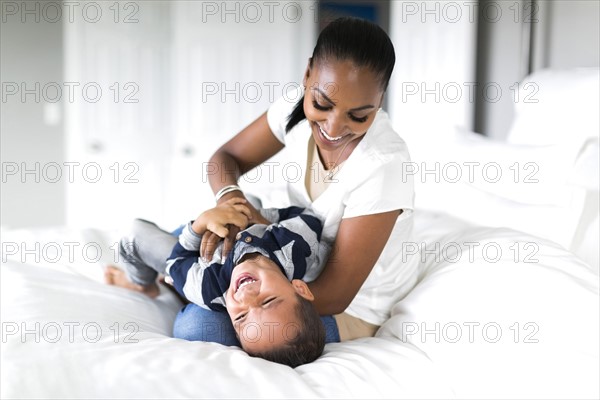 Mother playing with son (2-5 months) in bedroom