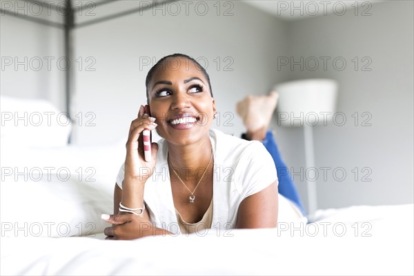 Woman lying on bed and using smart phone