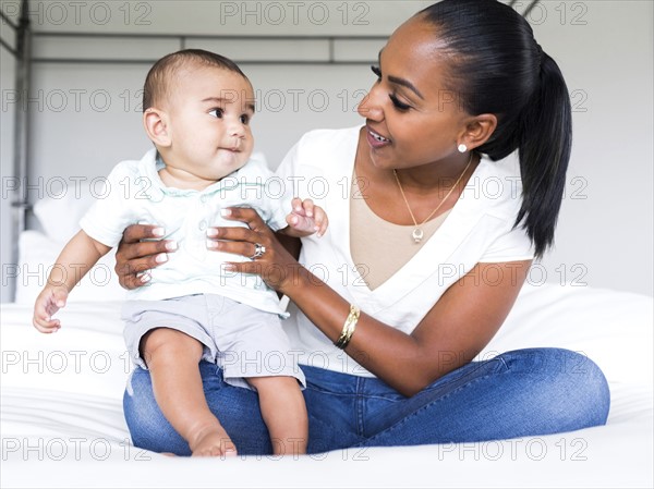 Mother holding baby boy (2-5 months) in bedroom