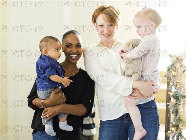 Portrait of mothers holding children (2-5 months, 12-17months)