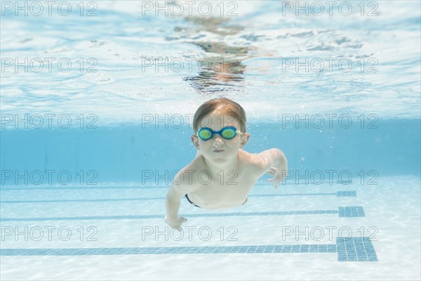 Boy (6-7) swimming in pool