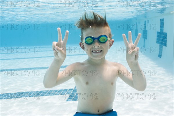 Portrait of boy (6-7) gesturing in swimming pool