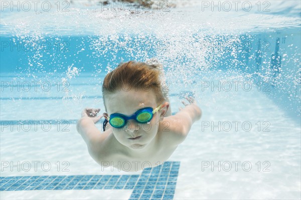 Boy (6-7) swimming in pool