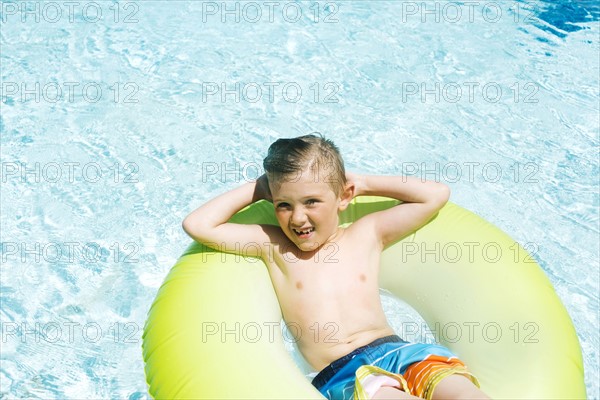 Boy (4-5) relaxing in inflatable ring