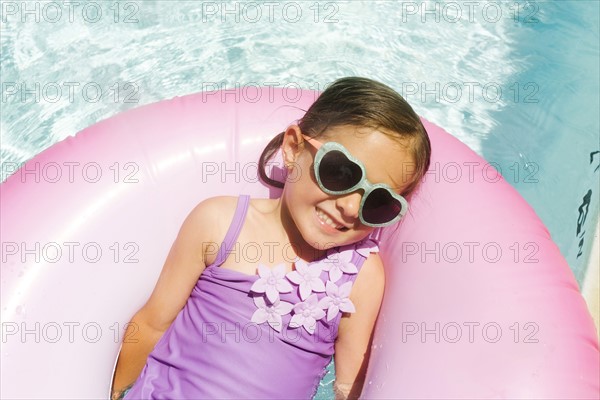 Smiling girl (4-5) relaxing in inflatable ring