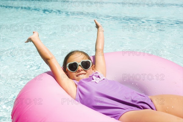 Smiling girl (4-5) relaxing in inflatable ring