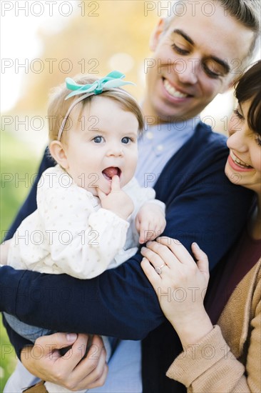 Parents holding daughter (12-17 months)