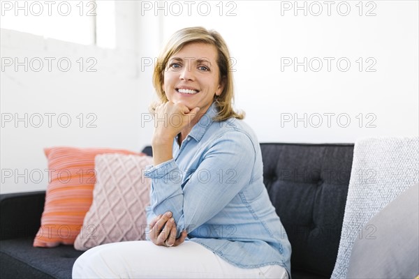 Portrait of happy Mature woman with hand on chin